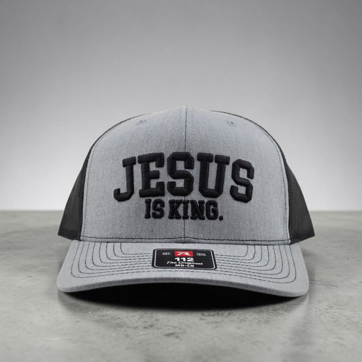 Jesus Is King Christian hat, 3D puff embroidered Richardson 112 trucker hat in heather grey and black - front view