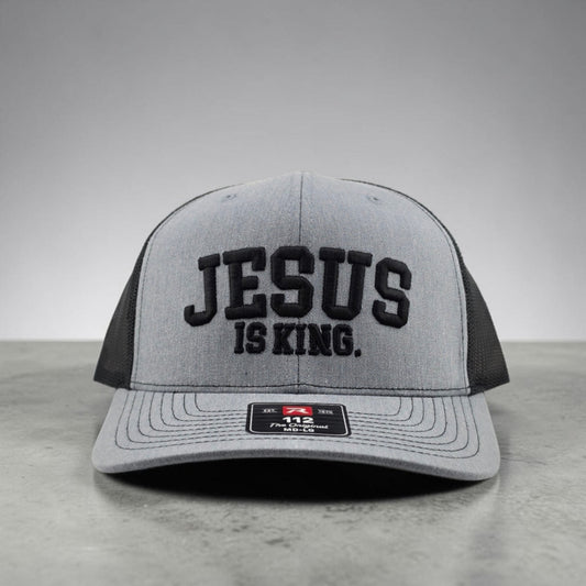 Jesus Is King Christian hat, 3D puff embroidered Richardson 112 trucker hat in heather grey and black - front view